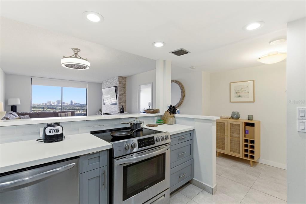 A kitchen with grey cabinets, stainless steel appliances, and a view of a city skyline — 500 THREE ISLANDS BOULEVARD UNIT 1008, HALLANDALE BEACH, FL