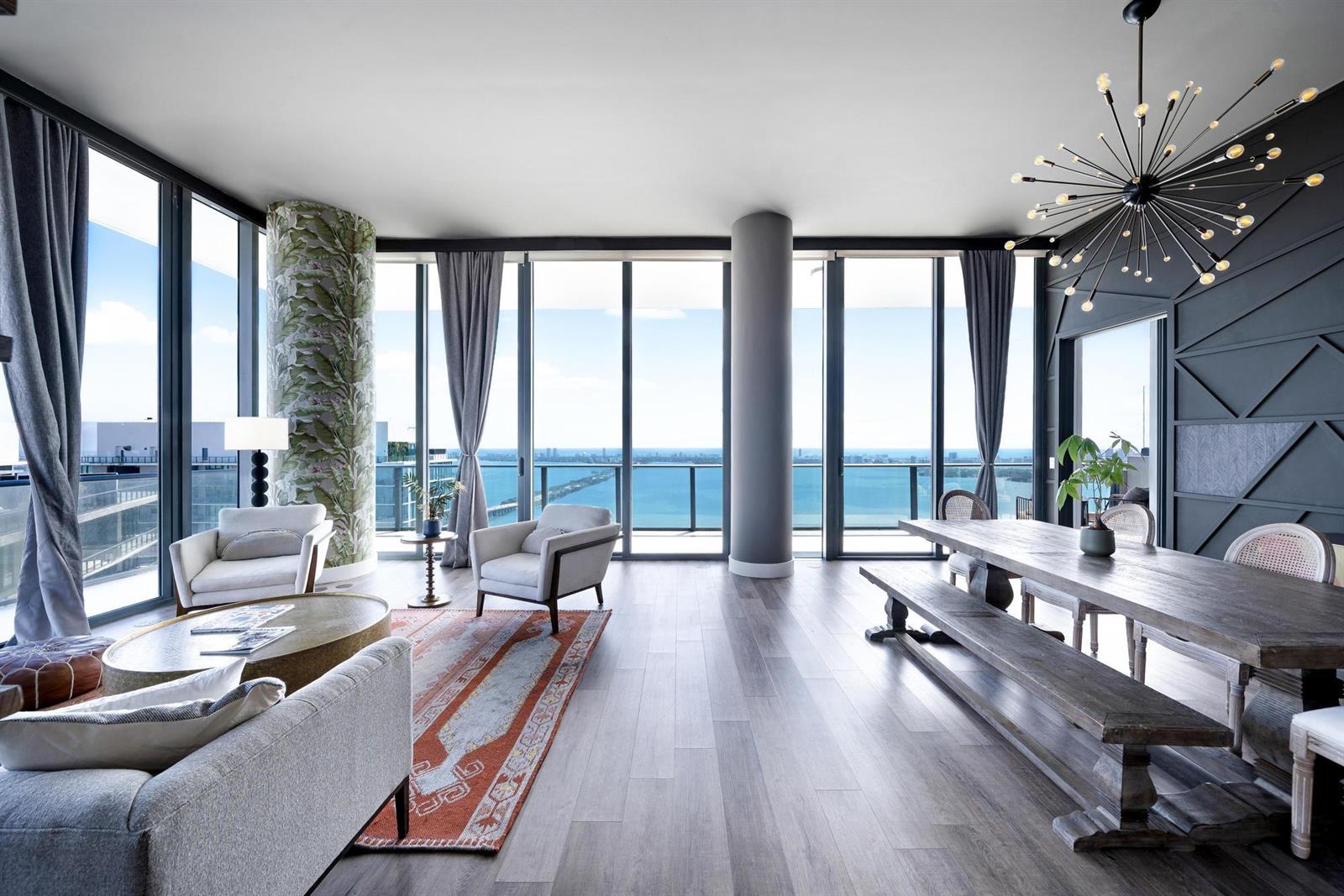 A modern living room features a cream sectional, glass coffee table, and floor-to-ceiling windows — 480 NE 31st Street, Miami FL 33137, MIAMI, FL