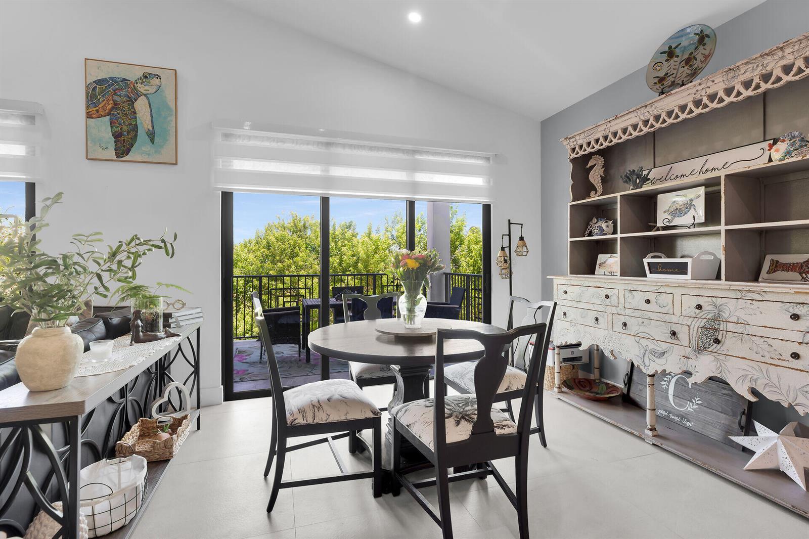 A dining area features a round table, four chairs, and a large distressed wooden hutch — 239 W Seaview Drive, FL 33050, FL