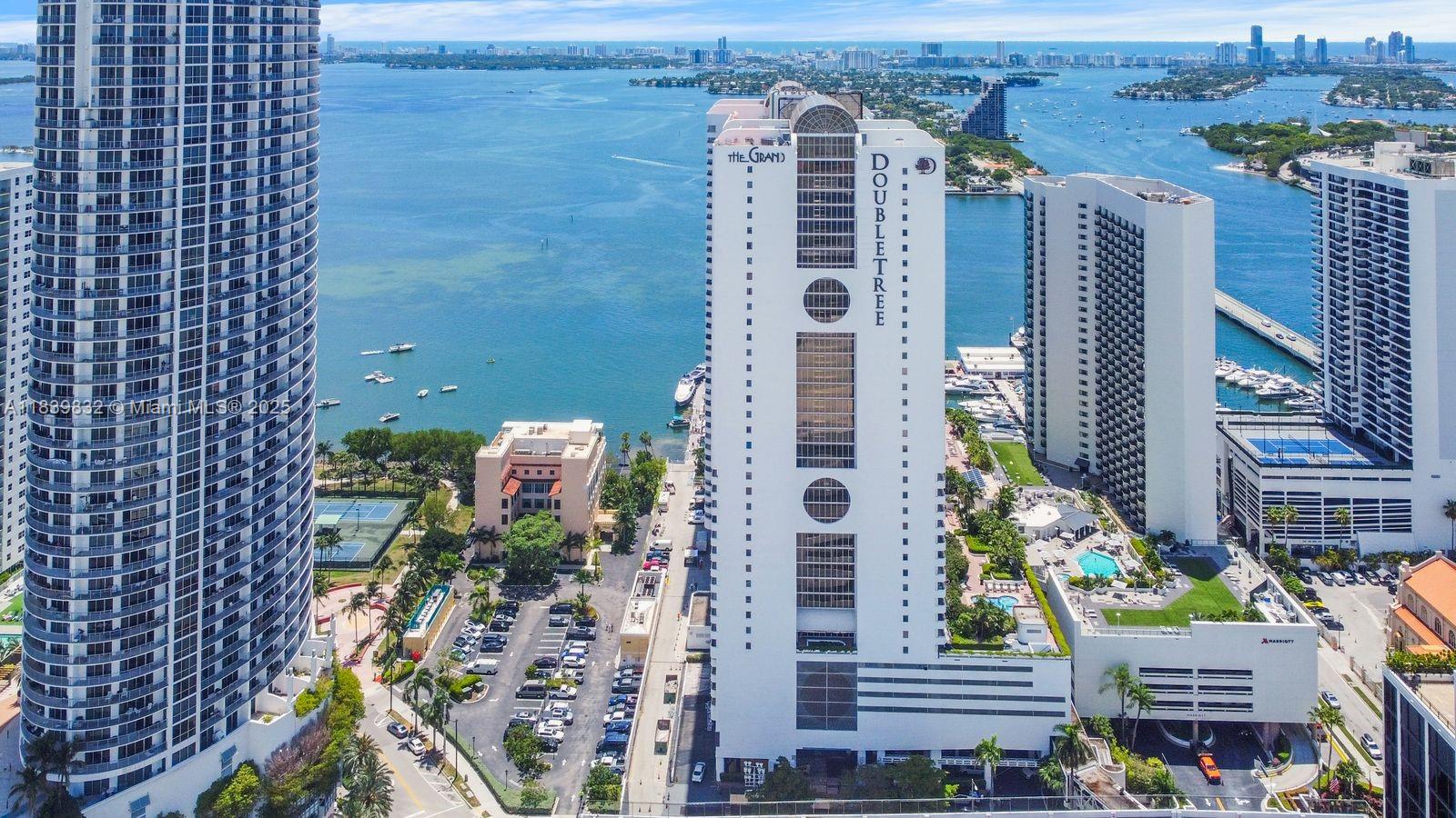 An aerial view of a tall DoubleTree hotel building situated along a waterfront in Miami — 1717 N Bayshore Dr # 2635, Miami FL 33132, MIAMI, FL