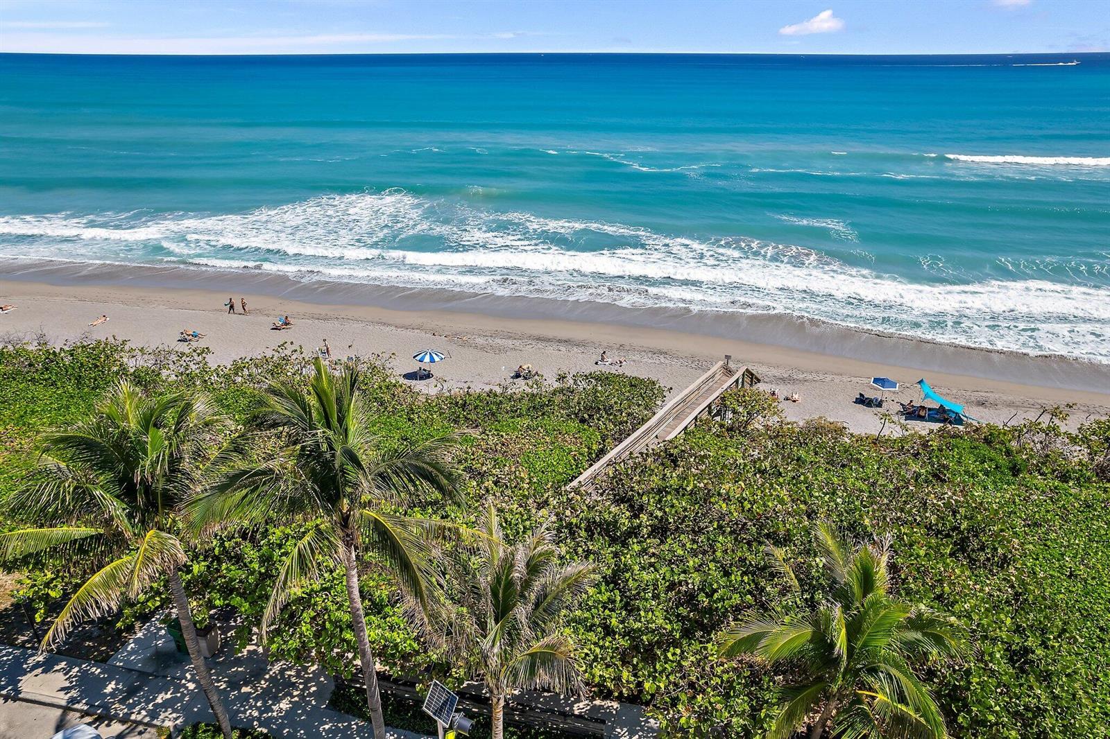 An elevated view of a sandy beach with palm trees and a wooden boardwalk — 1660 S Hwy A1a # 122, Jupiter FL 33477, JUPITER, FL