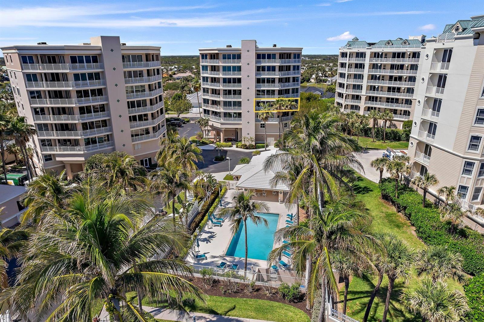 An aerial view shows three multi-story apartment buildings surrounding a central swimming pool and palm trees — 1660 S Hwy A1a # 122, Jupiter FL 33477, JUPITER, FL