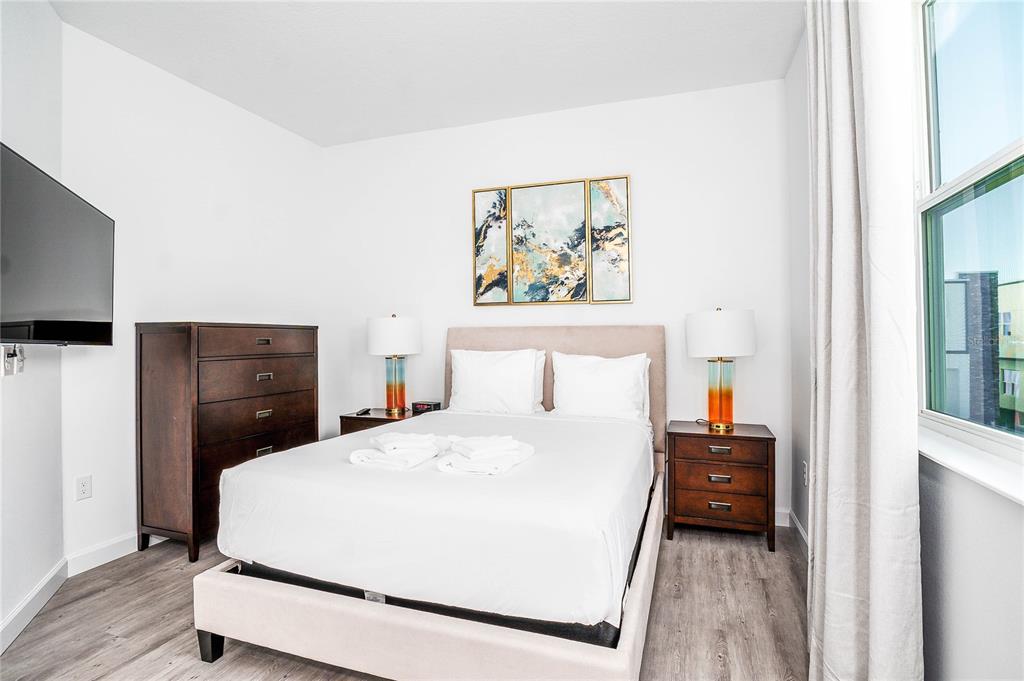 A modern two-story townhouse exterior features white panels, gray stone accents, and a paved parking lot — 277 FAMAGUSTA DRIVE, DAVENPORT, FL