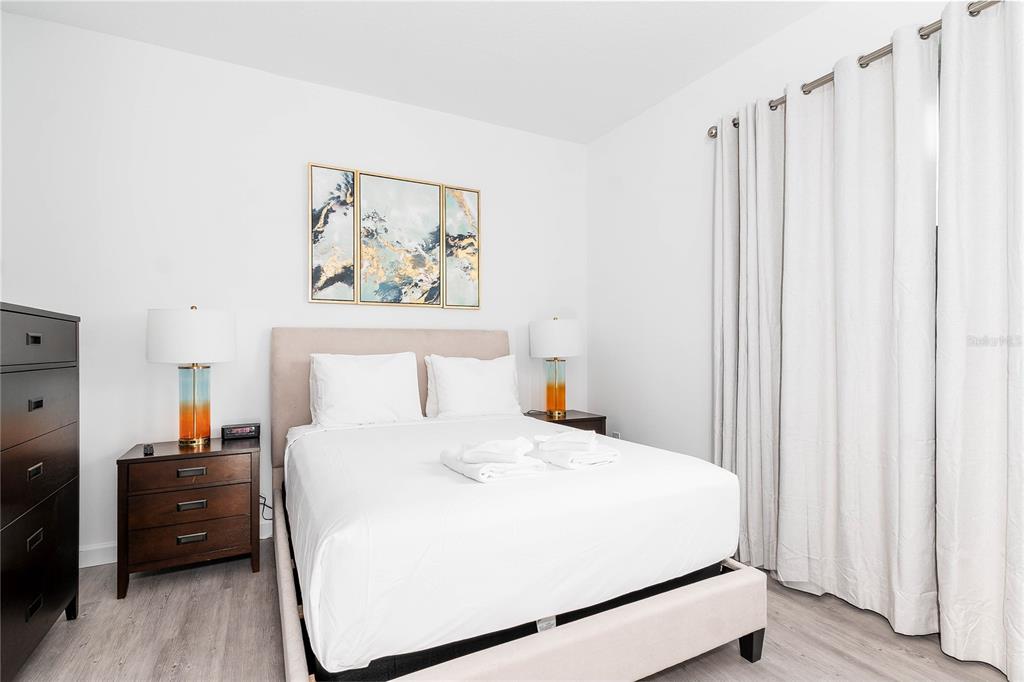 A bedroom features a bed with a light-colored headboard, two nightstands, and a dark dresser — 277 FAMAGUSTA DRIVE, DAVENPORT, FL