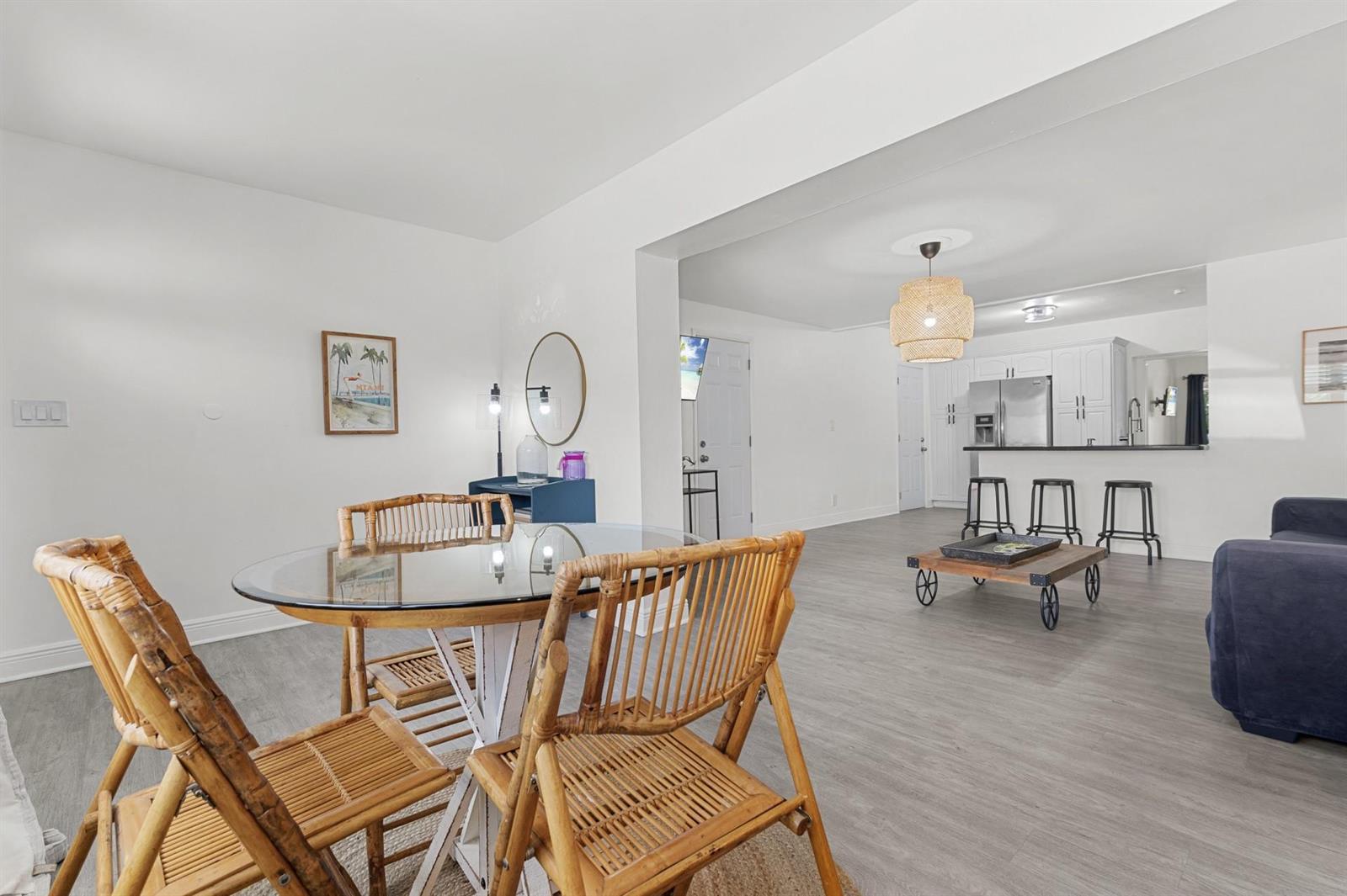 A dining area with a glass-topped table and bamboo chairs opens into a kitchen — 6375 SW 29th Street, Miami FL 33155, MIAMI, FL