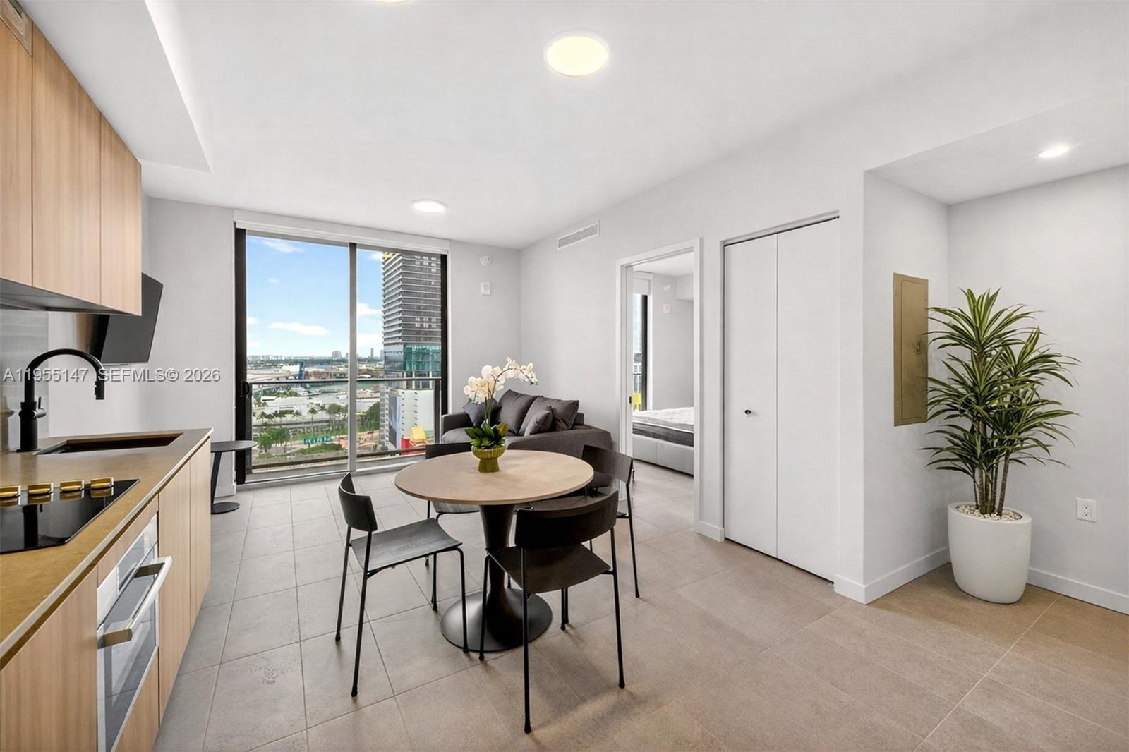 A modern apartment features a kitchen, dining area, and living space with floor-to-ceiling windows — 121 NE 5th Street # 1913, Miami FL 33132, MIAMI, FL