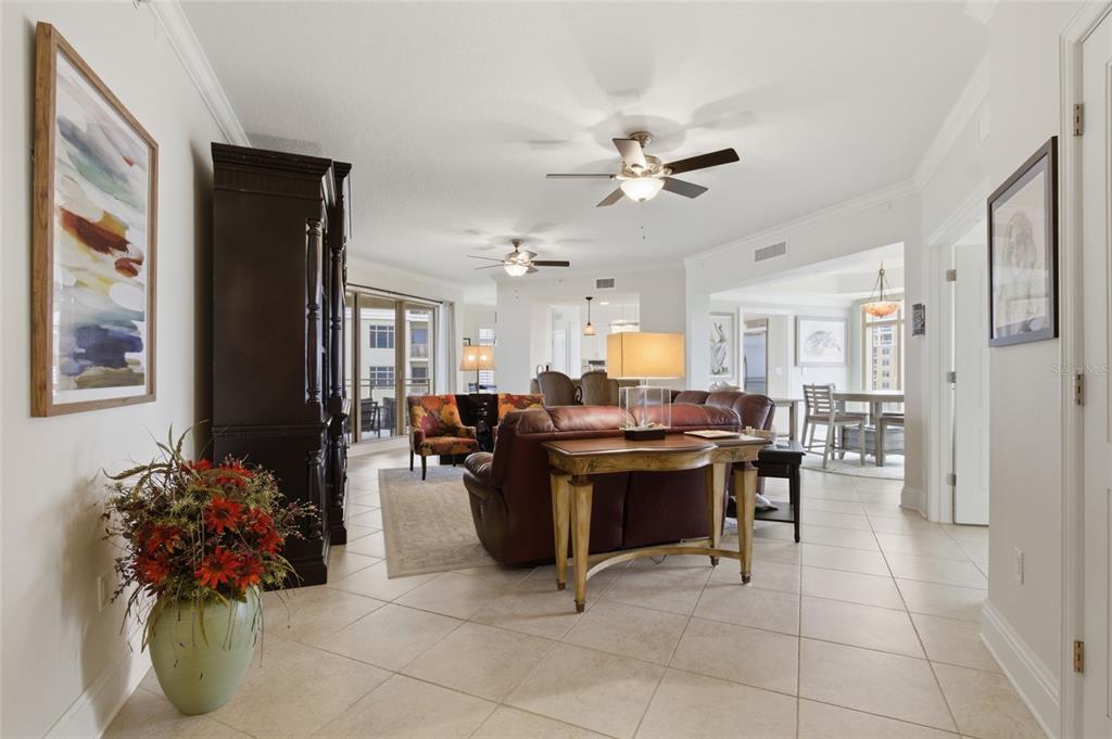 An open-concept living and dining area features tile flooring, ceiling fans, and neutral walls — 11 BAYMONT STREET UNIT 608, CLEARWATER BEACH, FL