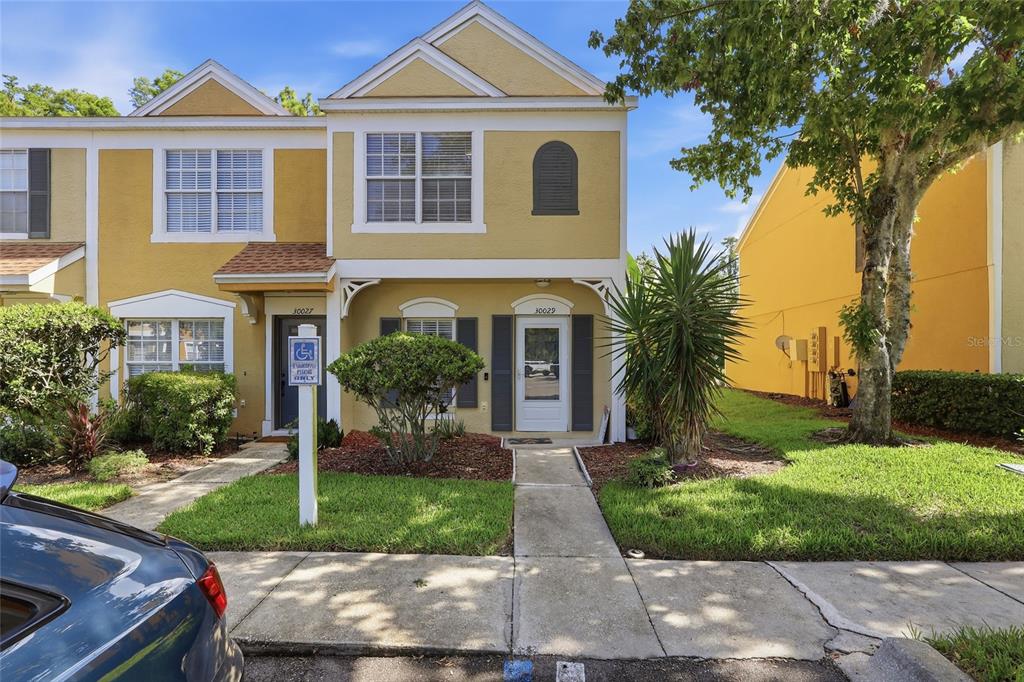 A two-story yellow townhouse with a sidewalk leading to two separate front entrances — 30029 GRANDA HILLS COURT, WESLEY CHAPEL, FL