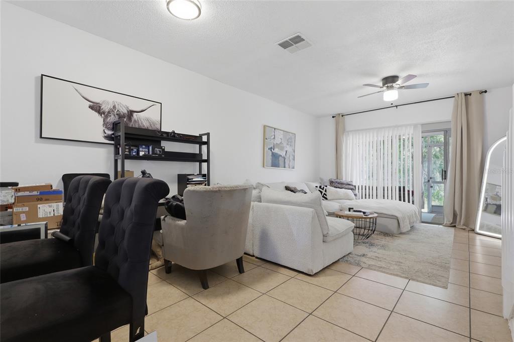 A living room features tile flooring, a white sectional sofa, and a sliding glass door — 30029 GRANDA HILLS COURT, WESLEY CHAPEL, FL