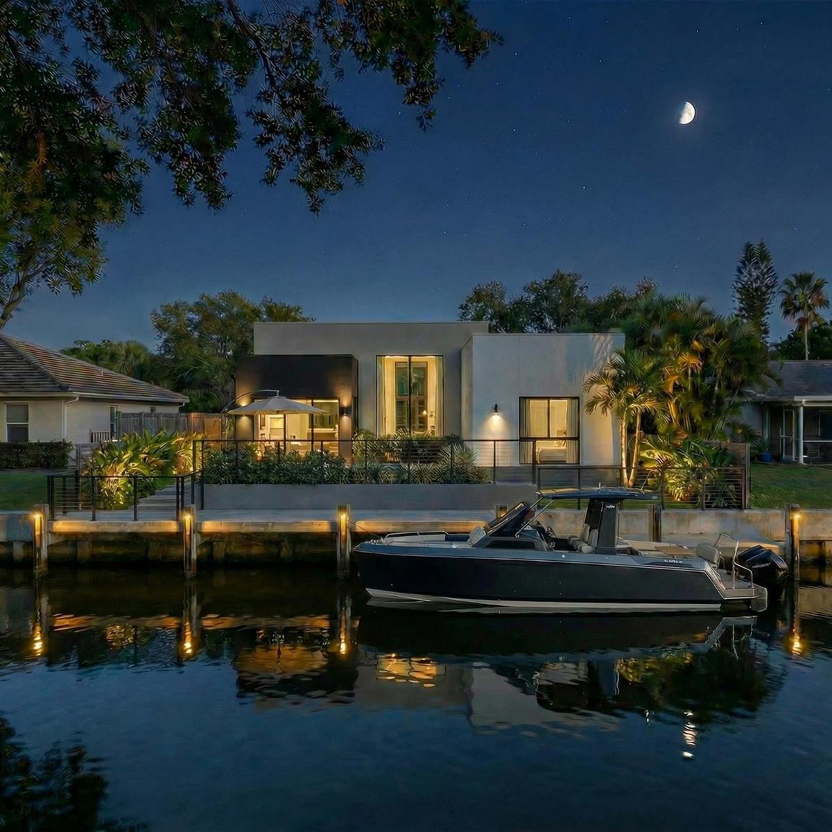 A modern house with a boat docked at a canal-side patio under a night sky — 2500 NE 18th Avenue, Wilton Manors FL 33305, WILTON MANORS, FL