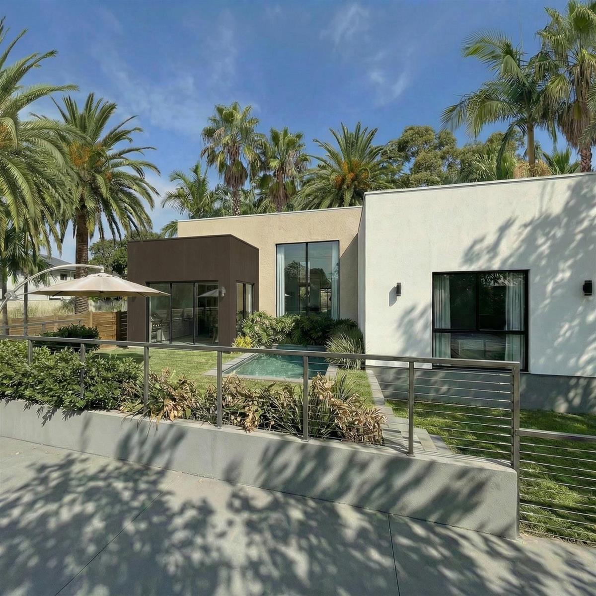 A modern house exterior features a small pool, palm trees, and a metal railing fence — 2500 NE 18th Avenue, Wilton Manors FL 33305, WILTON MANORS, FL