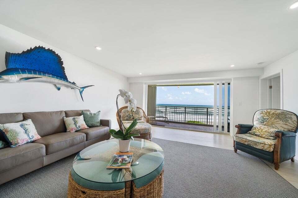 A living room features a large sailfish wall sculpture, a brown sofa, and ocean views — 350 S Beach Road # 305, Jupiter FL 33469, JUPITER, FL