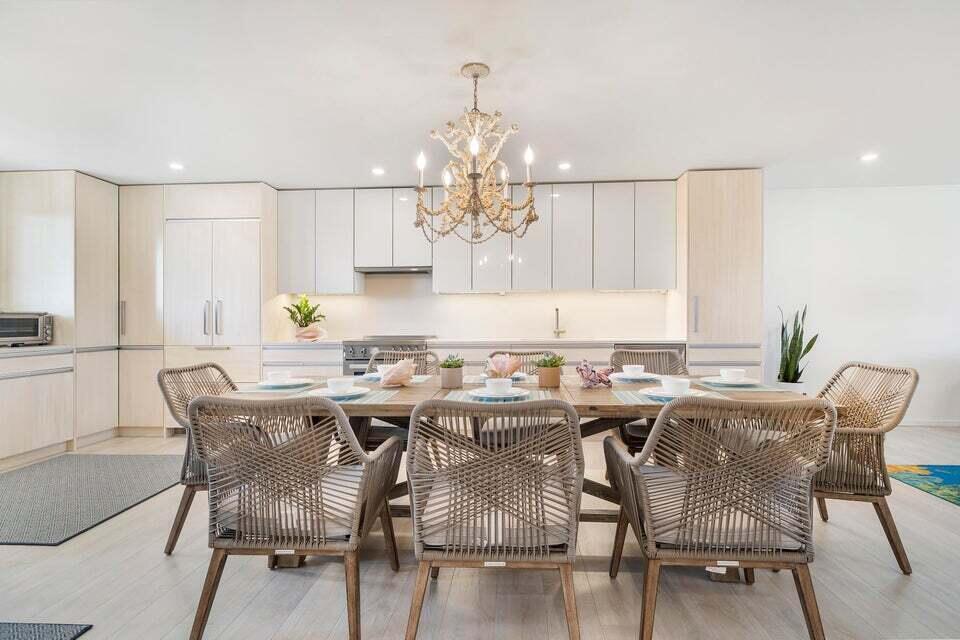 A modern kitchen and dining area feature light wood cabinetry and a woven-chair dining set — 350 S Beach Road # 305, Jupiter FL 33469, JUPITER, FL