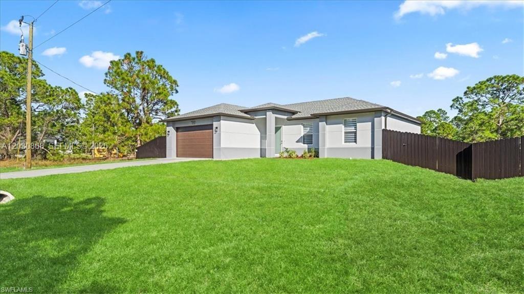 A single-story house with a brown garage door and a dark fence on a lawn — 759 SILVERSTAR AVE S, Lehigh Acres FL 33974, LEHIGH ACRES, FL