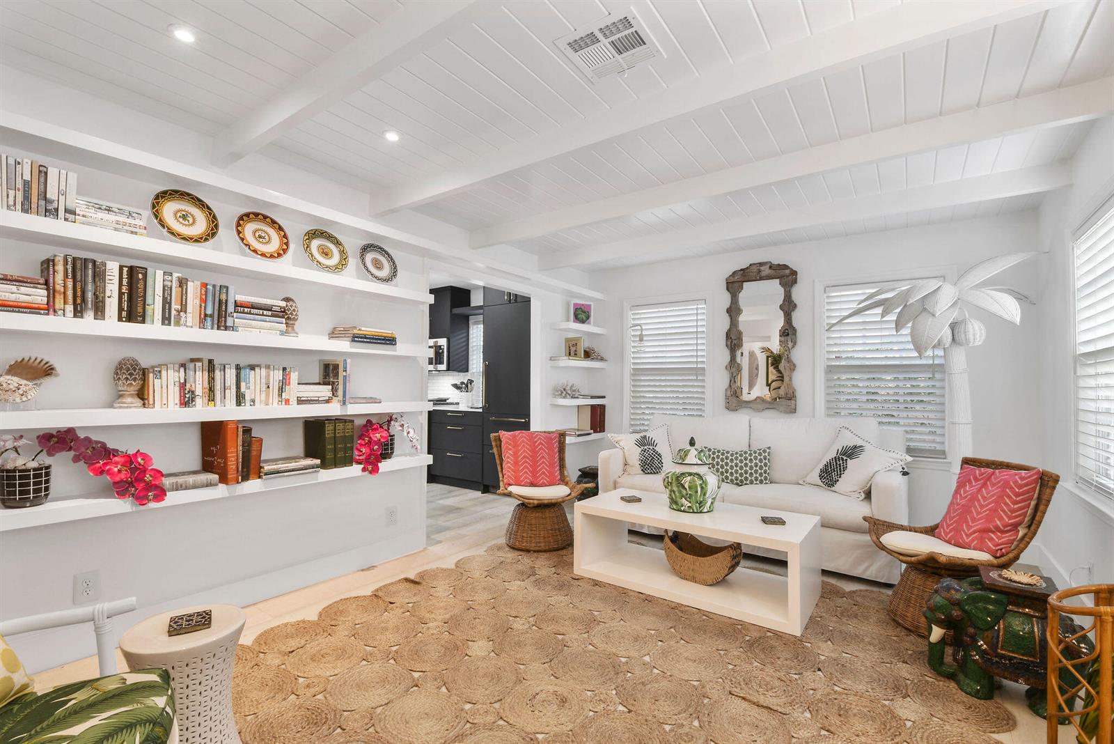 A bright living room features white built-in bookshelves, a white sofa, and a jute rug — 612 N Palmway, FL 33460, FL