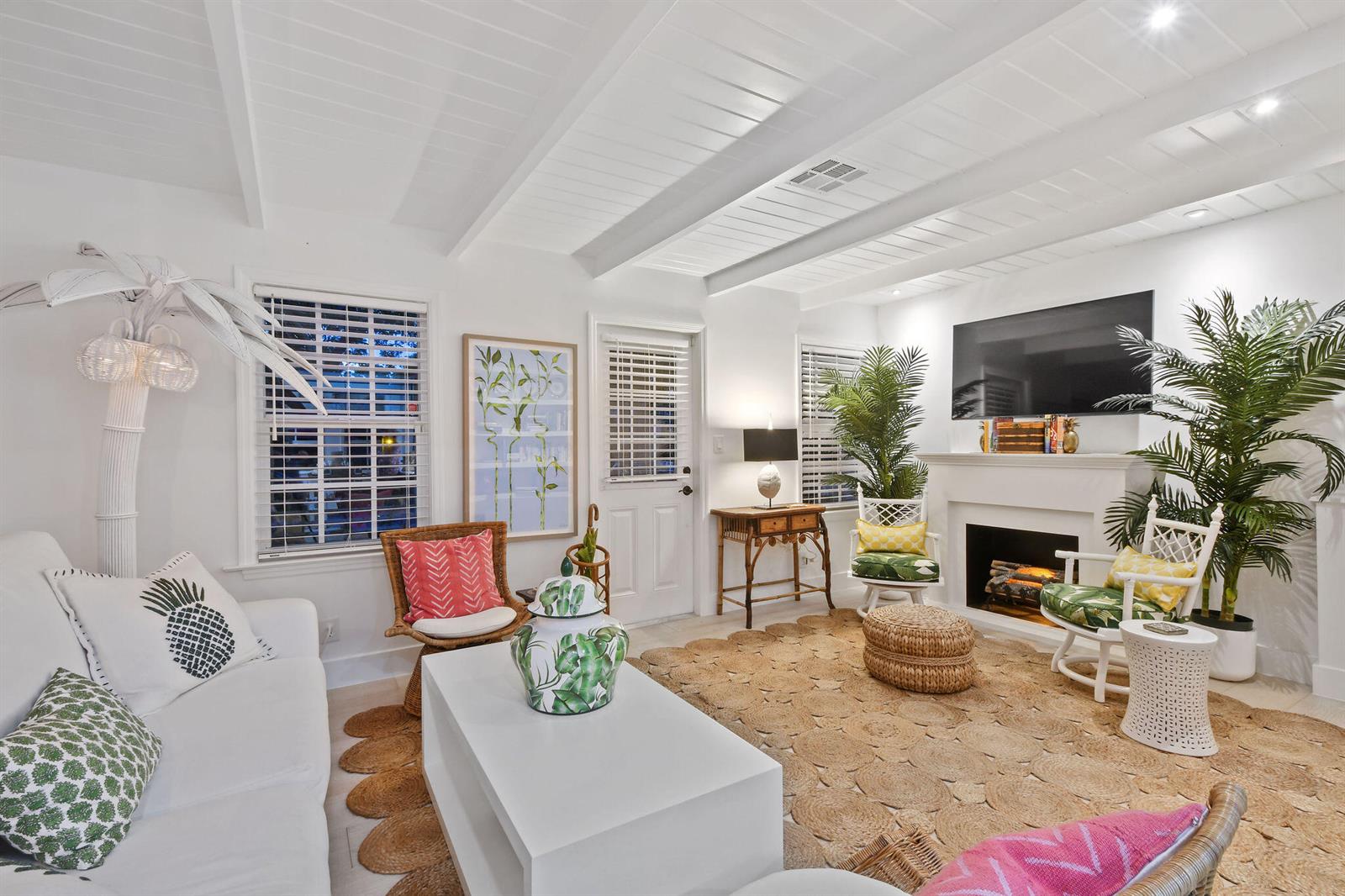 A bright living room features white shiplap ceilings, a fireplace, and tropical-themed decor — 612 N Palmway, FL 33460, FL