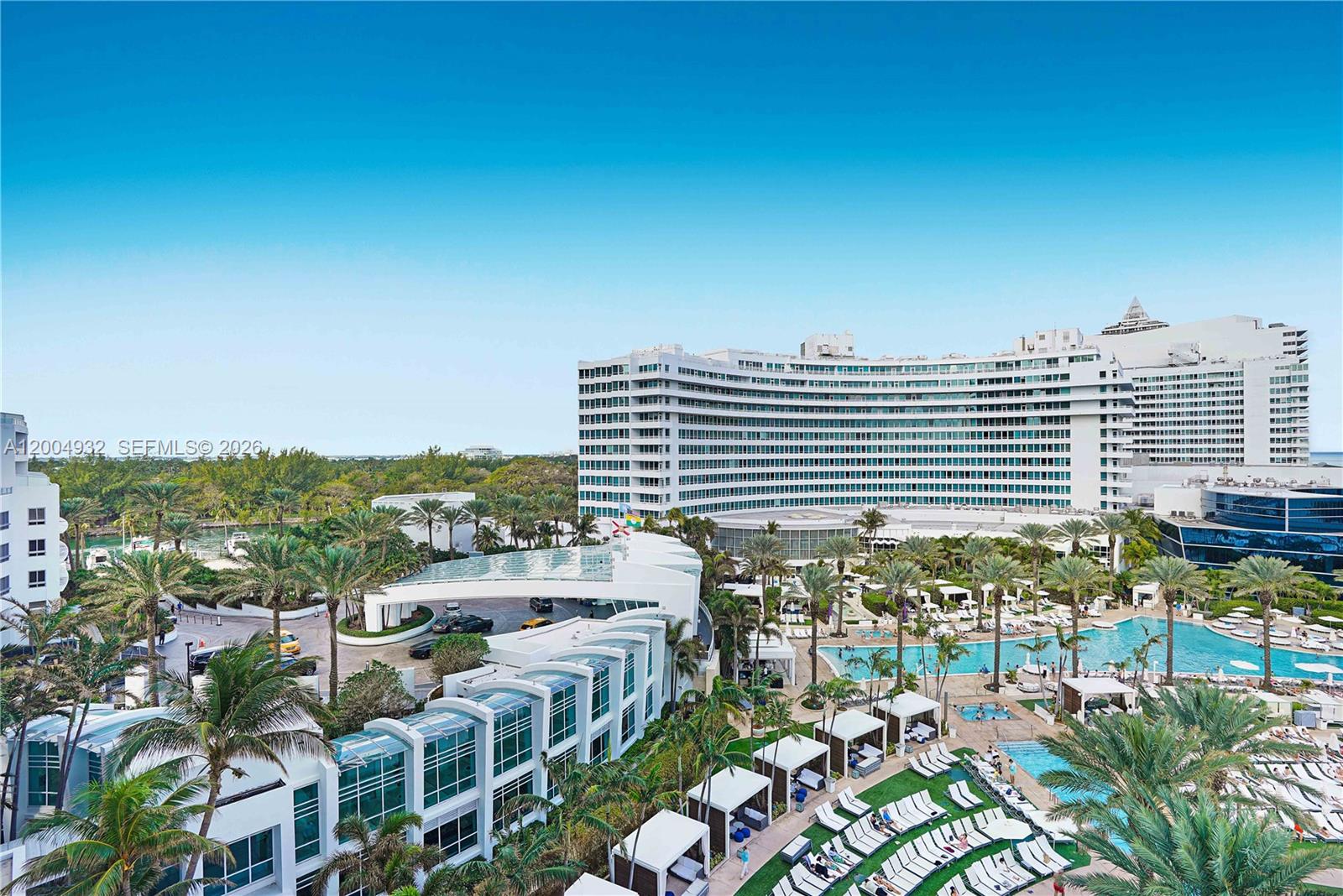 An aerial view shows a large resort hotel with a pool, cabanas, and palm trees — 4391 Collins Ave # 709, Miami Beach FL 33140, MIAMI BEACH, FL