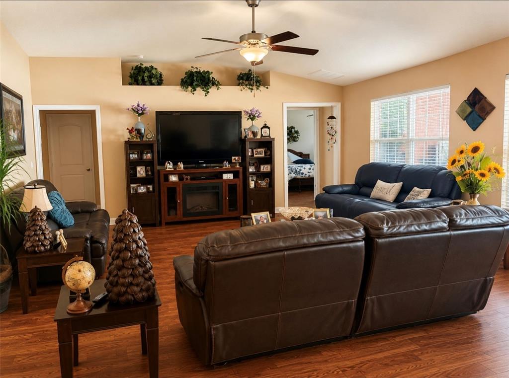 A living room features a dark leather sofa, a coffee table, and wood-look flooring — 3 RAE JUNE PLACE, PALM COAST, FL