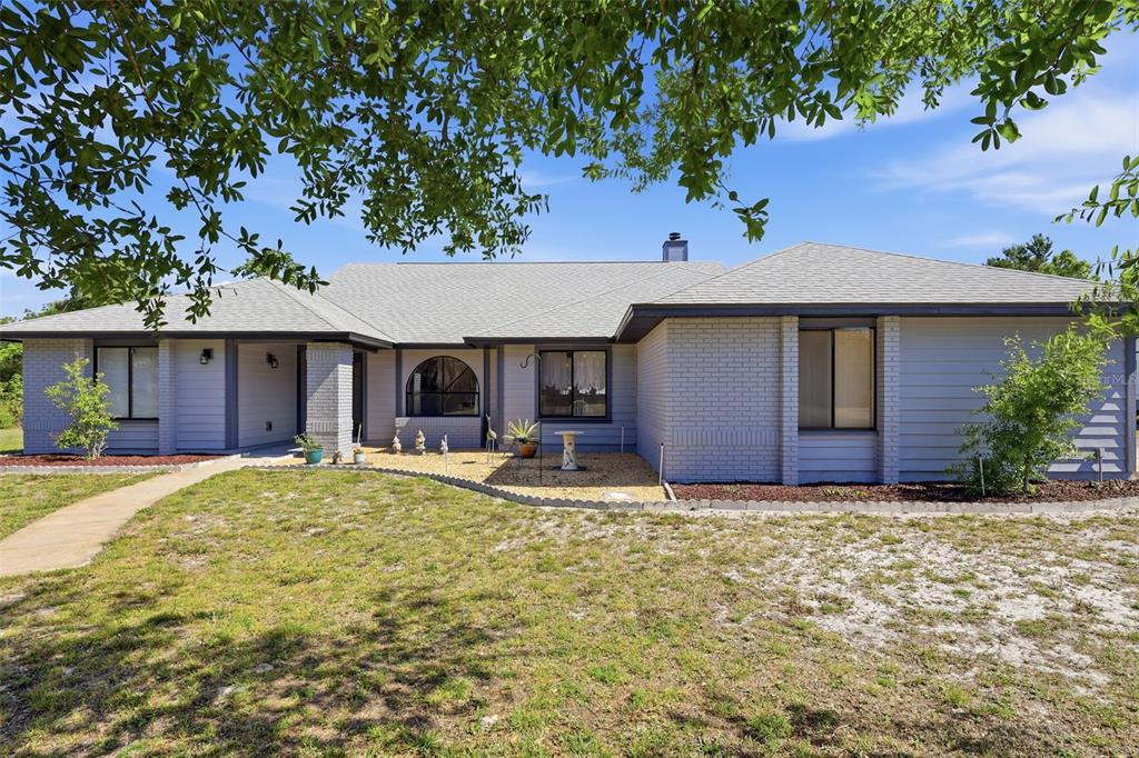 A single-story house with a gray brick and siding exterior, a shingled roof, and landscaping — 168 COMMUNITY DRIVE, DEBARY, FL