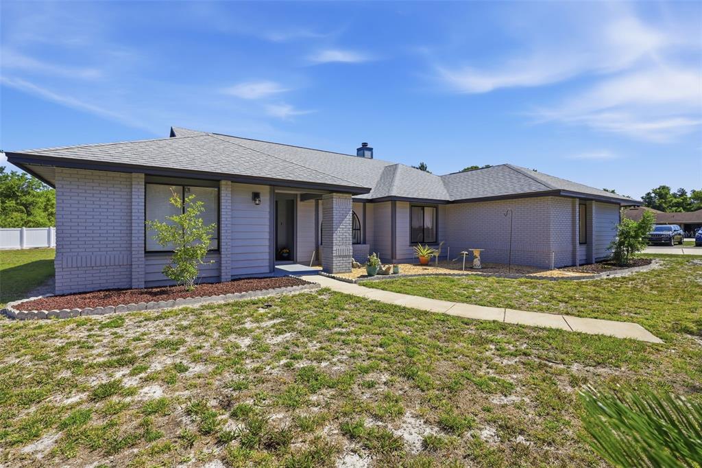 A single-story gray brick house with a hip roof and a concrete walkway — 168 COMMUNITY DRIVE, DEBARY, FL