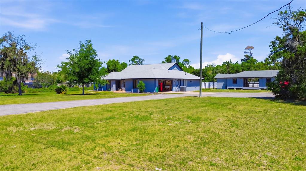 A blue house with a gray roof sits on a large, grassy lot — 168 COMMUNITY DRIVE, DEBARY, FL