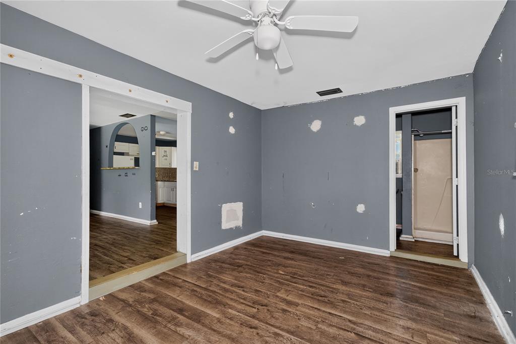 An unfurnished room with gray walls, wood-look flooring, a ceiling fan, and two doorways — 1510 MABRY STREET, TALLAHASSEE, FL