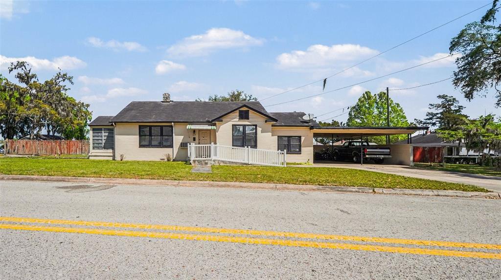 A single-story house with a carport, a wheelchair ramp, and a light-colored brick exterior — 219 SW 6TH STREET, OCALA, FL