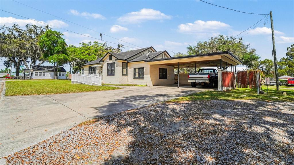 A single-story house with a carport, a gravel driveway, and a white wheelchair ramp — 219 SW 6TH STREET, OCALA, FL