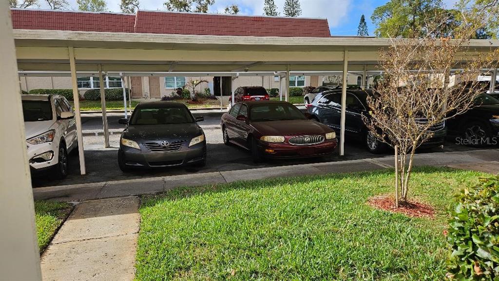 A covered parking area features several parked cars in front of a residential building — 10035 63RD AVENUE N UNIT 6, ST PETERSBURG, FL