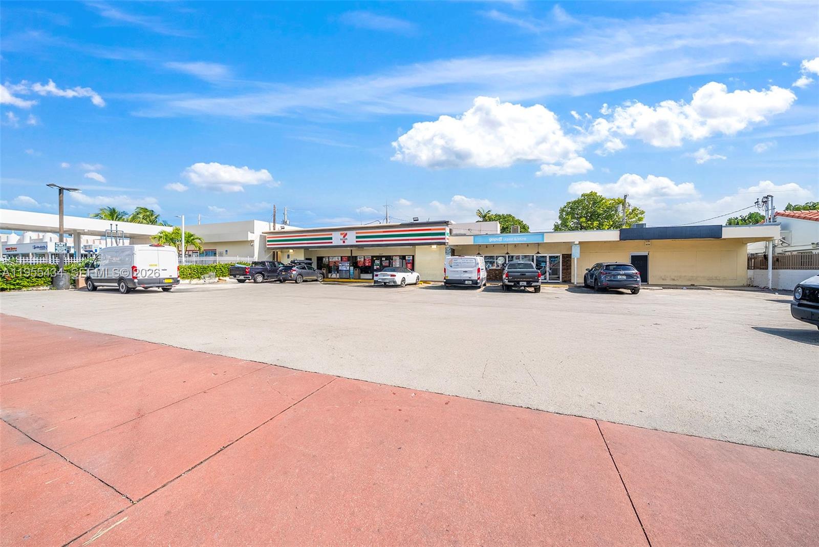 A 7-Eleven store and adjacent retail space with a large parking lot under blue skies — 1441 Alton Rd, Miami Beach FL 33139, MIAMI BEACH, FL