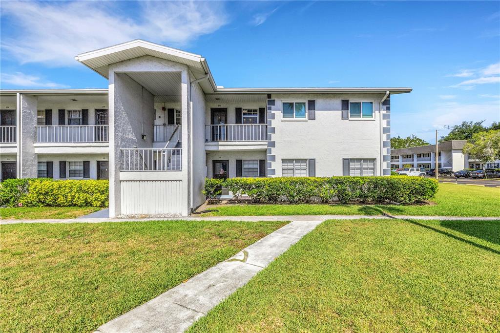A two-story apartment building with a white stucco exterior and a central covered staircase — 105 47TH AVENUE DRIVE W UNIT 376, BRADENTON, FL