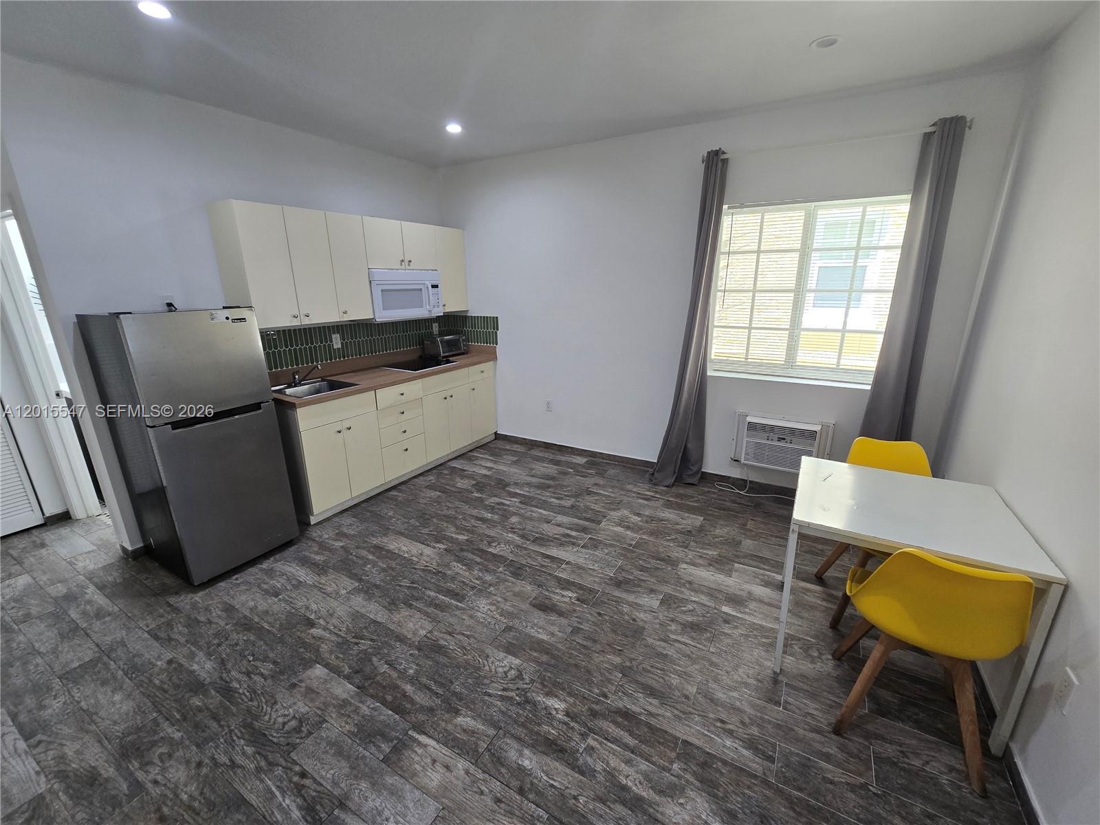 A kitchen with light-colored cabinets, stainless steel appliances, and a small dining area — 1345 Pennsylvania Ave # 5B, Miami Beach FL 33139, MIAMI BEACH, FL