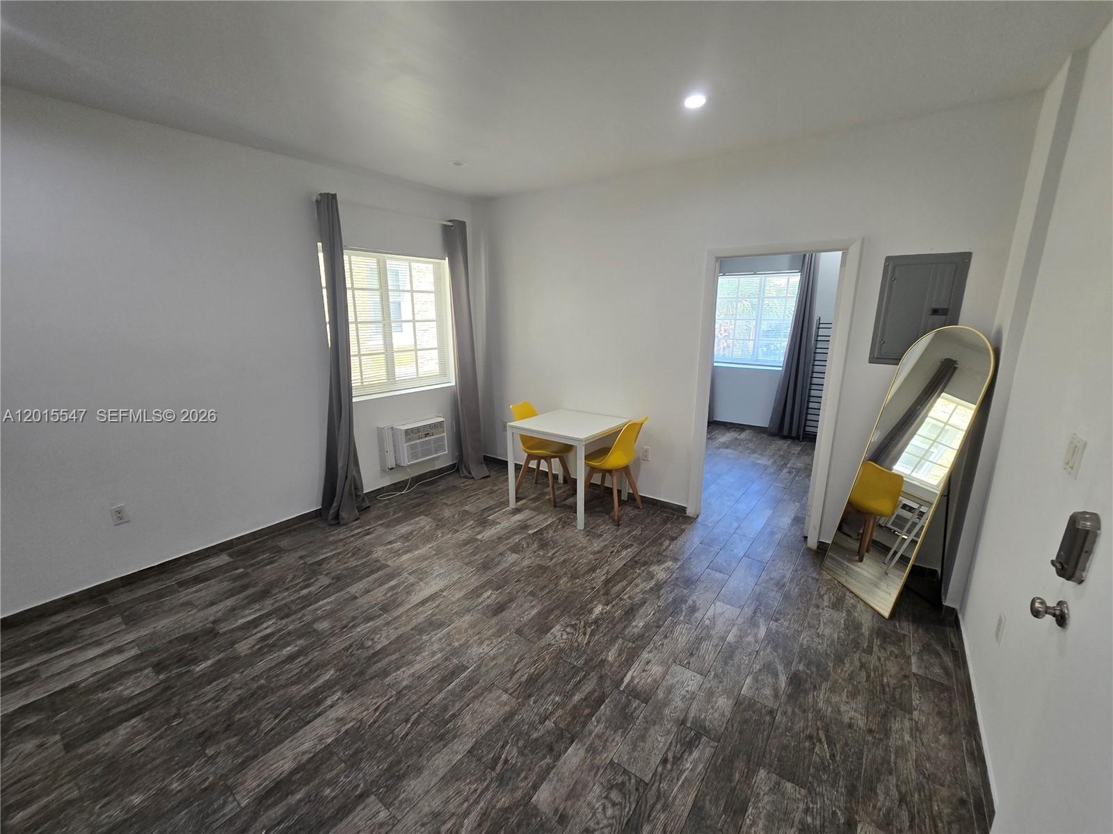 A room features wood-look tile flooring, a small dining set, and a full-length mirror — 1345 Pennsylvania Ave # 5B, Miami Beach FL 33139, MIAMI BEACH, FL
