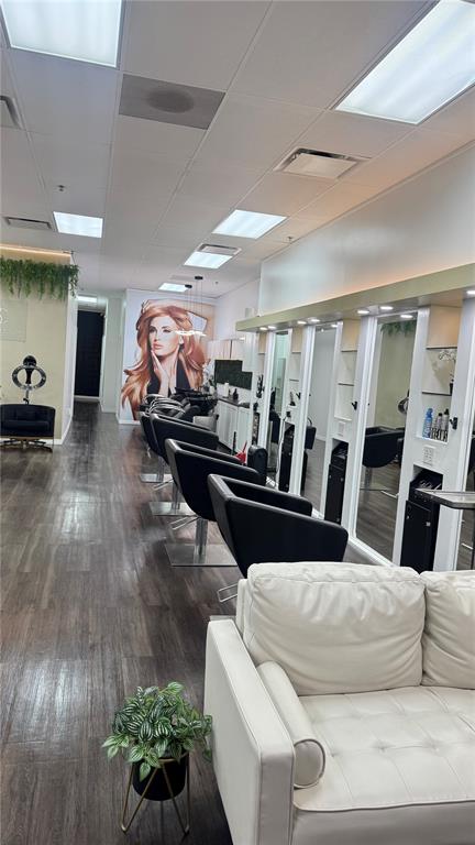 A hair salon interior features black styling chairs, white mirrors, and a white leather sofa — 13871 W HILLSBOROUGH AVENUE, TAMPA, FL