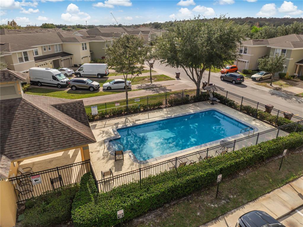 An aerial view shows a rectangular swimming pool enclosed by a black metal fence — 2018 CYPRESS BAY BOULEVARD, KISSIMMEE, FL