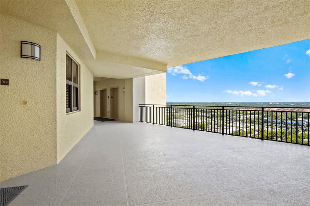 An outdoor balcony features a textured floor, a black metal railing, and a scenic view — 14380 RIVA DEL LAGO DRIVE UNIT 1804, FORT MYERS, FL