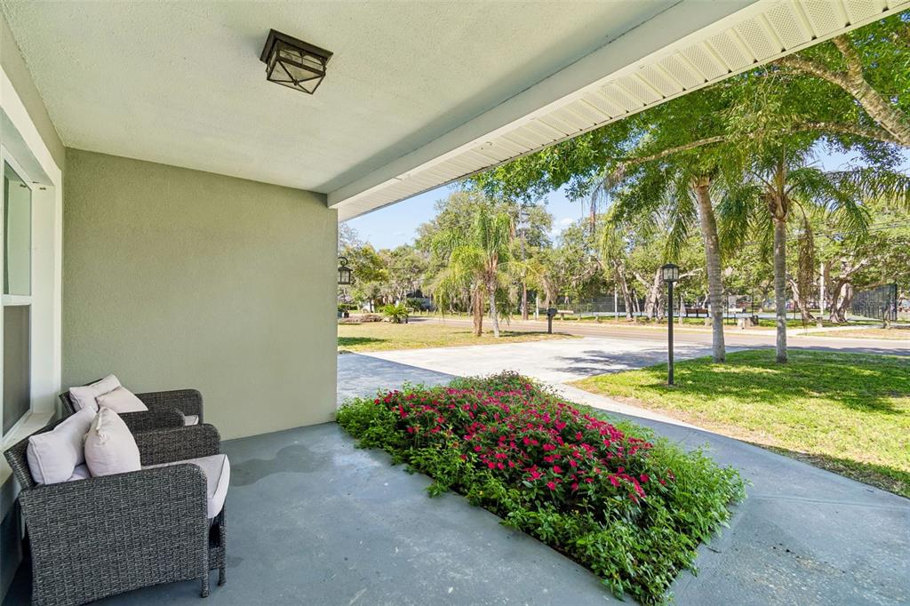 A backyard swimming pool is enclosed by a black mesh safety fence on a brick patio — 12417 N ROME AVENUE, TAMPA, FL