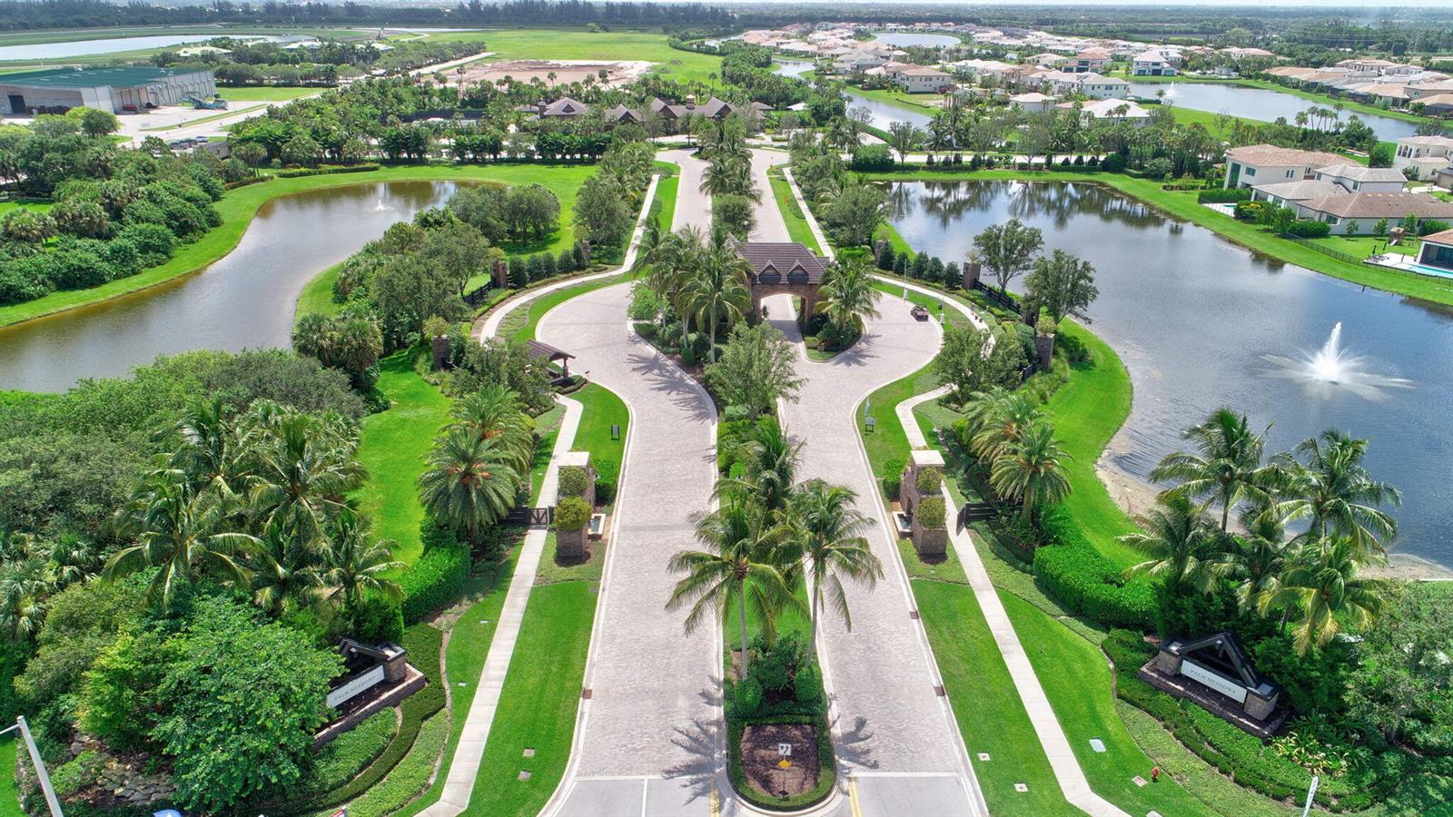 An aerial view shows the gated entrance to a residential community with ponds and palm trees — 8787 Grand Prix Lane, Boynton Beach FL 33472, BOYNTON BEACH, FL