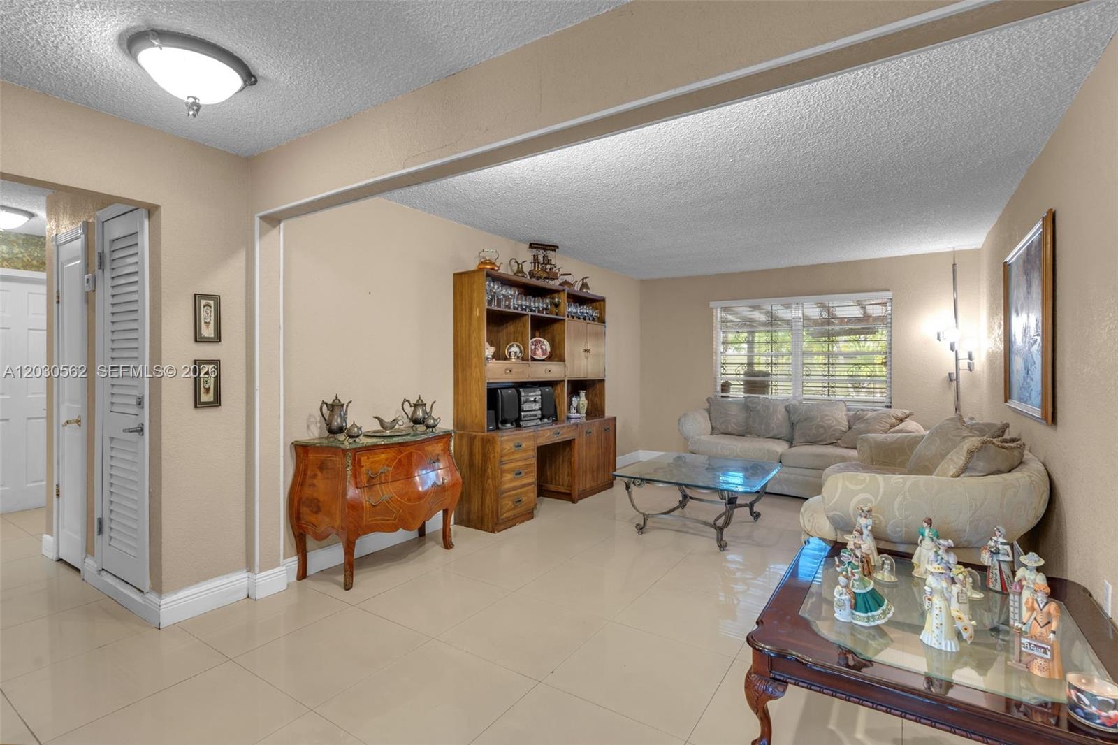 A living room features beige walls, tile flooring, a wooden hutch, and traditional furniture — 1320 SW 84th Ave, Miami FL 33144, MIAMI, FL