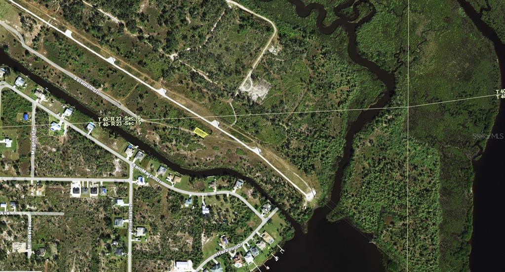 This aerial map shows a highlighted vacant lot located near a waterway and residential streets — 1547 BELASCO COURT, PUNTA GORDA, FL