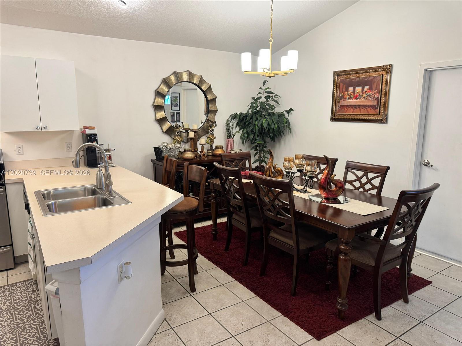 A dining area with a dark wood table and chairs sits on a red rug — 2330 SW 80th Ter, Miramar FL 33025, MIRAMAR, FL