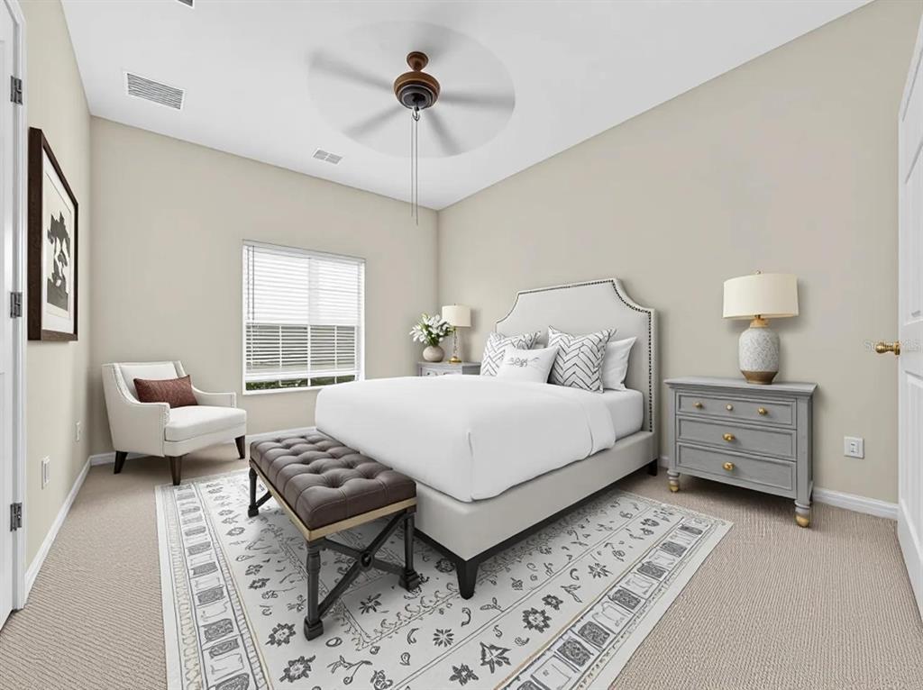 A bedroom featuring a bed with a tufted bench, two nightstands, and a corner chair — 10411 PARK COMMONS DRIVE, ORLANDO, FL