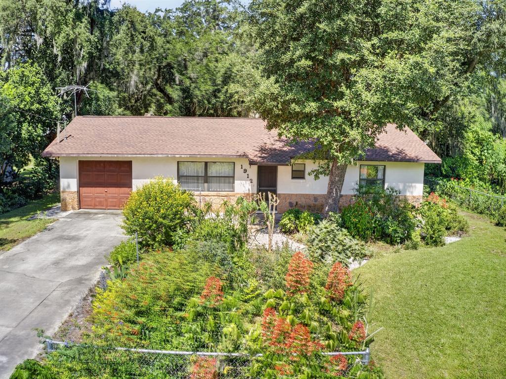 A single-story house with a brown roof, stone base, and a front-facing garage — 1912 SE 169TH COURT, SILVER SPRINGS, FL