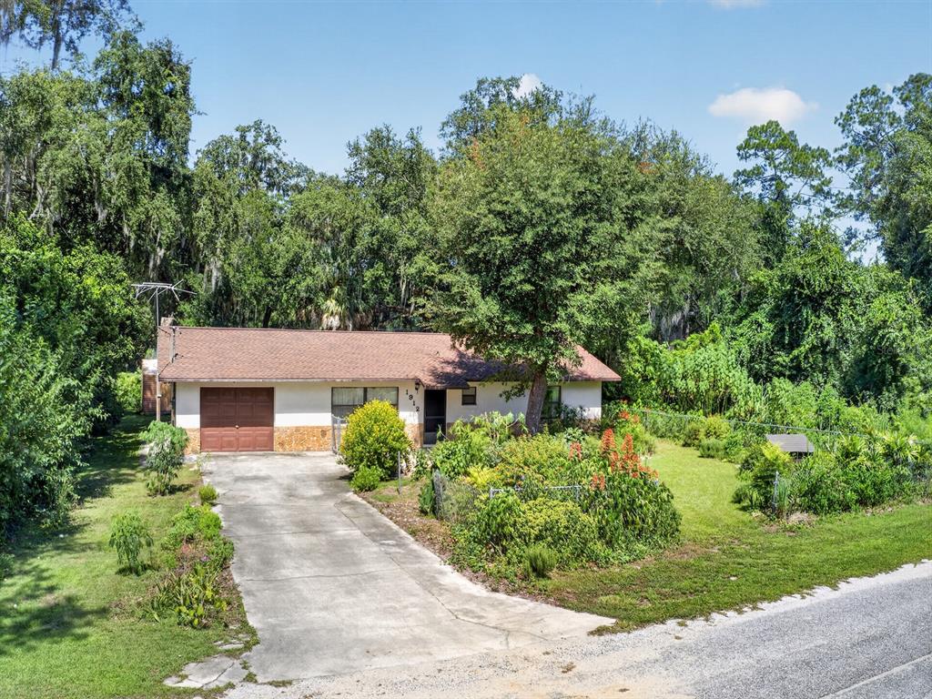 A single-story house with a brown roof, white walls, and a concrete driveway — 1912 SE 169TH COURT, SILVER SPRINGS, FL