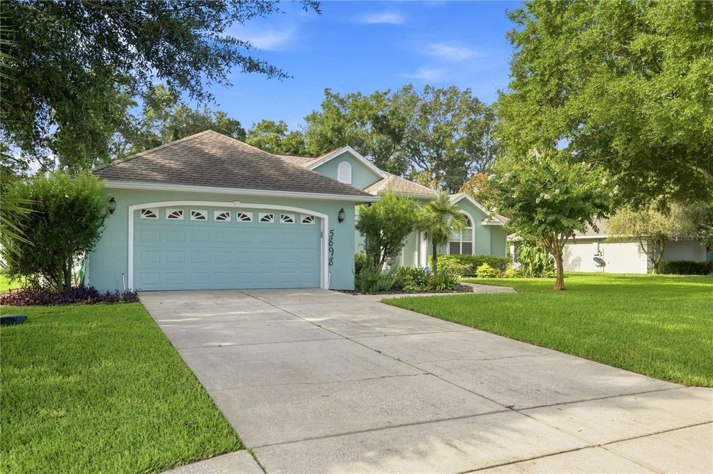 A light green single-story house with a two-car garage and a concrete driveway — 5898 SW 89TH PLACE, OCALA, FL
