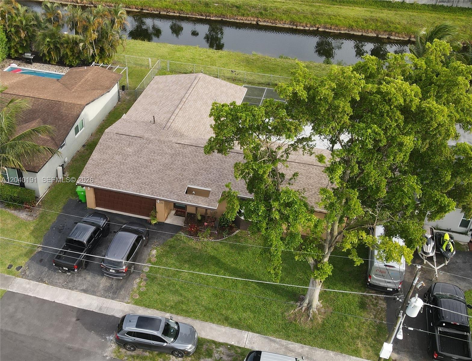 An aerial view shows a single-story house with a large tree and multiple parked vehicles — 8330 NW 20th Ct, Sunrise FL 33322, SUNRISE, FL