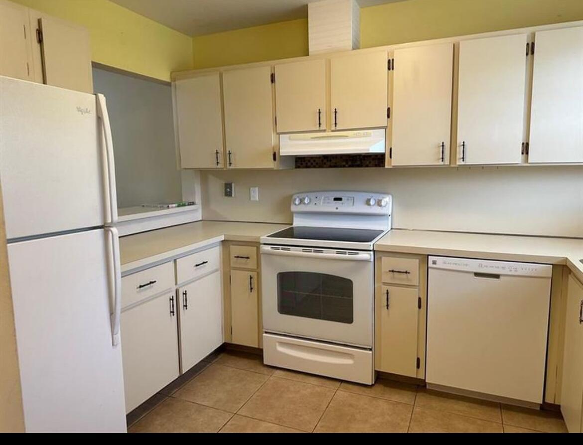 A kitchen with white cabinets, white appliances, and tan tile flooring — 8682 Satalite Terrace, West Palm Beach FL 33403, WEST PALM BEACH, FL