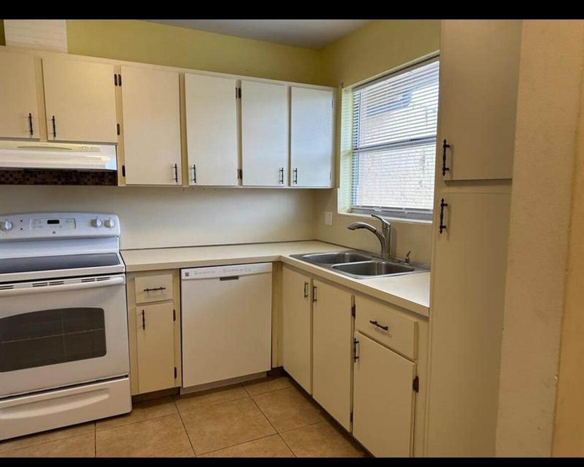 A kitchen with white cabinets, a white dishwasher, a white stove, and a double sink — 8682 Satalite Terrace, West Palm Beach FL 33403, WEST PALM BEACH, FL