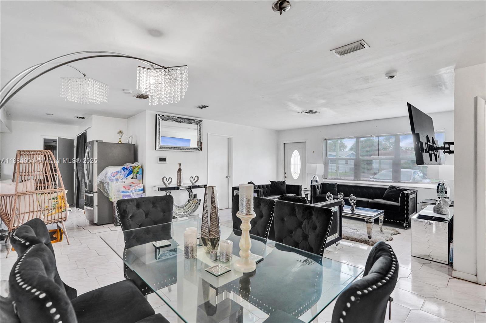 A dining area and living room feature black tufted furniture, a glass table, and tile floors — 320 N 71st Ave, Hollywood FL 33024, HOLLYWOOD, FL