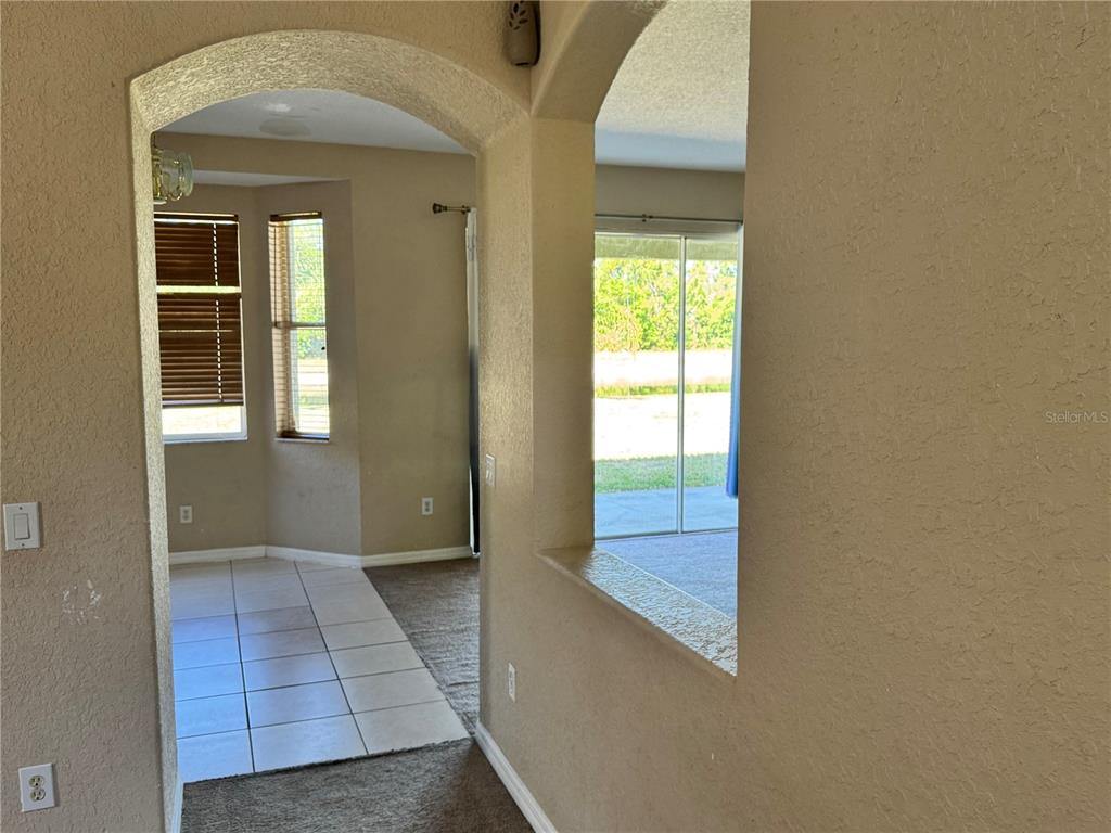 An arched doorway leads to a tiled breakfast nook and a carpeted living area — 9023 PINEBREEZE DRIVE, RIVERVIEW, FL